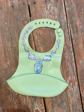 Load image into Gallery viewer, Blue lariat necklace on green no drip baby bib